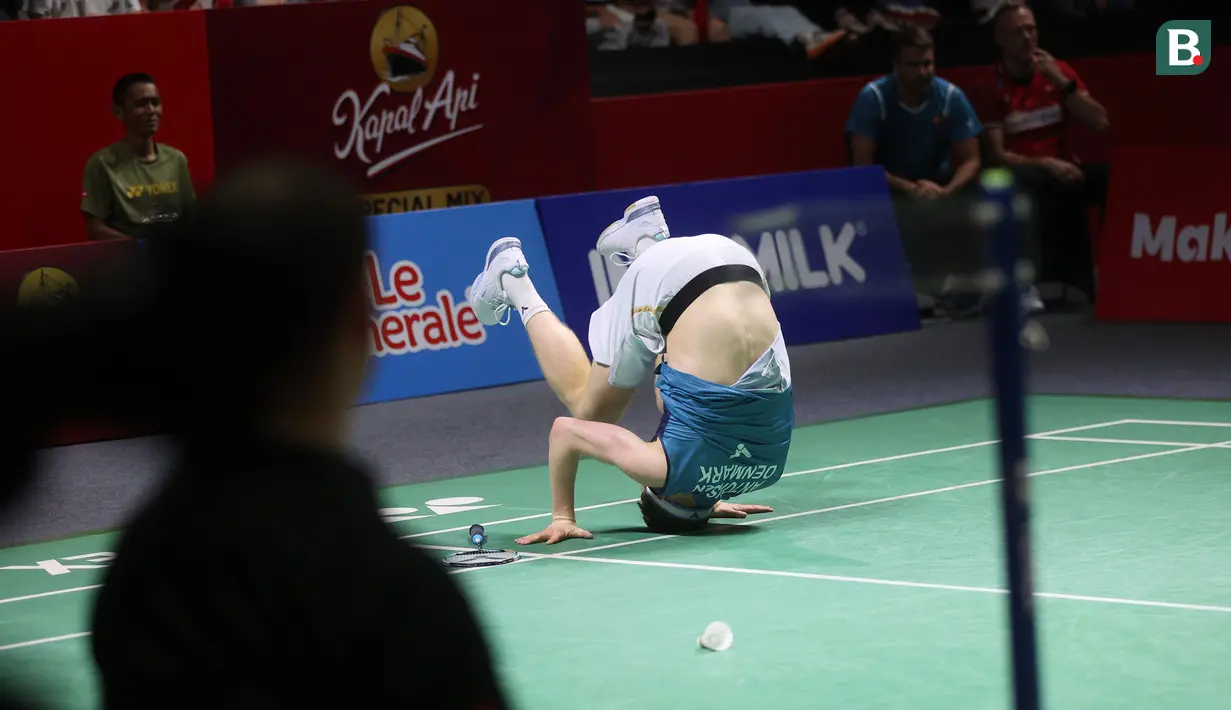 <p>Pebulu tangkis tunggal putra Denmark, Anders Antonsen jatuh bangun di lapangan setelah gagal mengembalikan bola saat menghadapi wakil China, Shi Yu Qi pada laga final turnamen bulu tangkis Indonesia Open 2024 di Istora Senayan, Jakarta, Minggu (9/6/2024). Anders Antonsen kalah rubber-game 9-21, 21-12 dan 14-21. (Bola.com/M Iqbal Ichsan)</p>