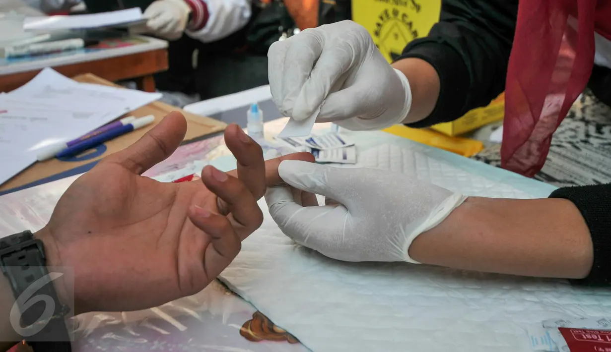 Petugas medis melakukan cek dan scanning darah kepada pengunjung Car Free Day, Jakarta, Minggu (13/12/2015). Mahasiswa UIN dan Yayasan Angsa Merah menggelar pemeriksaan darah gratis guna memperingati hari AIDS sedunia. (Liputan6.com/Yoppy Renato)