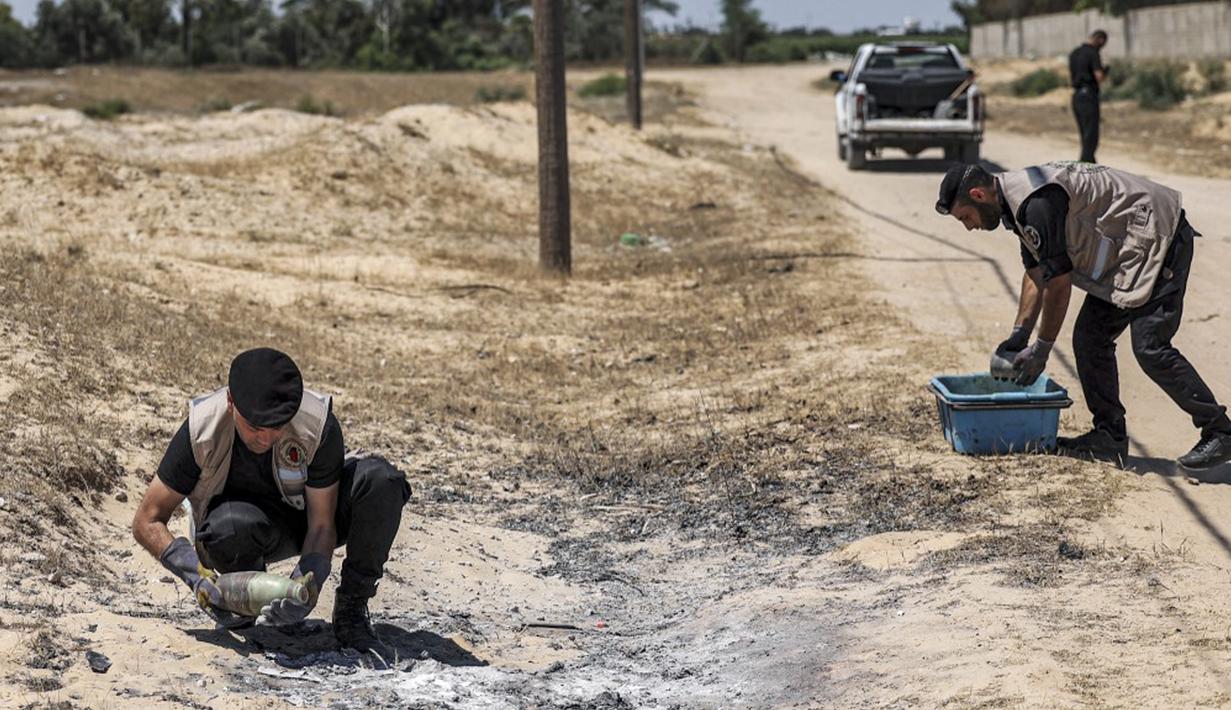 Pakar bahan peledak Hamas mengambil proyektil yang tidak meledak setelah konflik Mei 2021 dengan Israel dari sebuah lapangan di Khan Yunis, Jalur Gaza, Sabtu (5/6/2021). Perang 11 hari antara Hamas dan Israel menewaskan 254 orang Palestina dan 12 orang Israel. (MAHMUD HAMS/AFP)