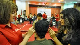 Relawan Starkey Hearing Foundation memakaikan alat bantu dengar pada seorang penyandang tunarungu di Gedung Kemensos, Jakarta, Jumat (27/3/2015). Alat ini diberikan gratis Kemensos bekerjasama dengan Starkey Hearing Foundation (Liputan6.com/Faizal Fanani)