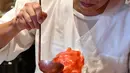 Pemilik toko Koji Morinishi menuangkan sirup ke es alami saat membuat kakigori di distrik Yanaka Tokyo, Jepang (21/6/2019). kakigori biasanya dihidangkan bersama aneka topping, potongan buah, es krim, hingga kacang merah. (AFP Photo/Toshifumi Kitamura)
