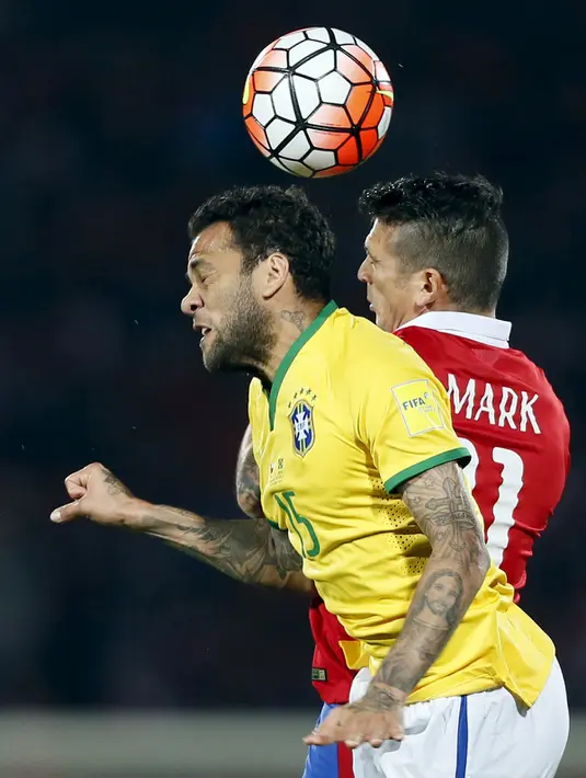 Bek Brasil, Dani Alves (kiri) berebut bola udara dengan gelandang Chile, Mark Gonzalez pada kualifikasi Piala Dunia 2018 di Santiago, Chili (8/10/2015). Chile menang atas Brasil dengan skor 2-0. (REUTERS/ Rodrigo Garrido)