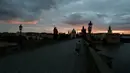 Seorang pria melintasi Jembatan Charles yang dibangun pada abad pertengahan di Praha, Republik Ceko, Kamis (8/10/2020). Ceko adalah salah satu negara terparah di Eropa Tengah dan Timur yang mengkonfirmasi lonjakan rekor infeksi COVID-19 selama beberapa pekan terakhir. (AP Photo/Petr David Josek)