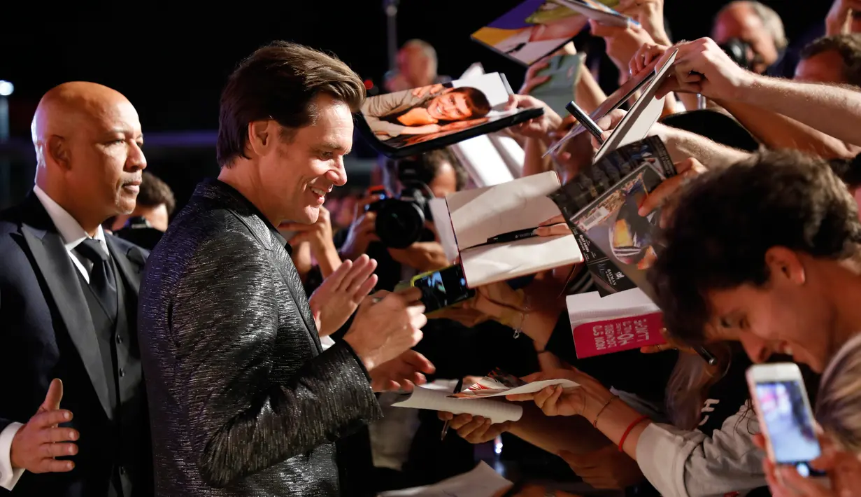 Aktor Jim Carrey memberi tanda tangan kepada penggemarnya saat menghadiri pemutaran film 'Jim and Andy: The Great Beyond' selama Festival Film Venice ke-74 di Venesia, Italia, (5/9). (AFP Photo/Domenico Stinellis)