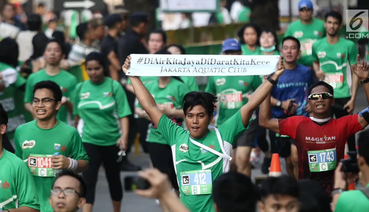 Peserta menunjukkan tulisan saat sampai di garis finis dalam Lomba lari MILO Jakarta International 10K 2017, Jakarta, Minggu (23/7). MILO Jakarta International 10K 2017 melombakan tiga kategori 10K, 5K dan Family Run 1,7K. (Liputan6.com/Faizal Fanani)