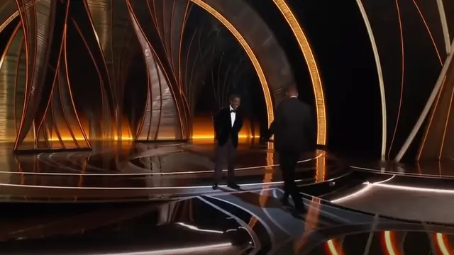 Will Smith naik ke panggung an menampar pembaca acara di Academy Awards 2022.