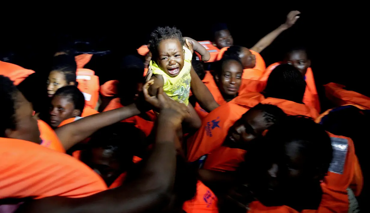 Seorang anak imigran menangis saat operasi penyelamatan di laut Mediterrania, (20/10). Penjaga pantai Italia mengatakan ribuan imigran berhasil diselamatkan di lepas pantai Libya. (Yara Nardi/Italian Red Cross press office/Handout via REUTERS)