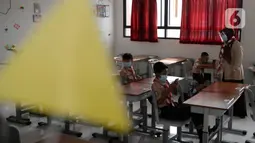 Guru mengajar para murid saat uji coba pembelajaran tatap muka di SDN Malaka Jaya 07 Jakarta, Rabu (9/6/2021). Uji coba pembelajaran tatap muka diikuti dengan jumlah siswa terbatas, menerapkan jaga jarak, dan mengenakan masker untuk menghindari penularan COVID-19. (merdeka.com/Imam Buhori)