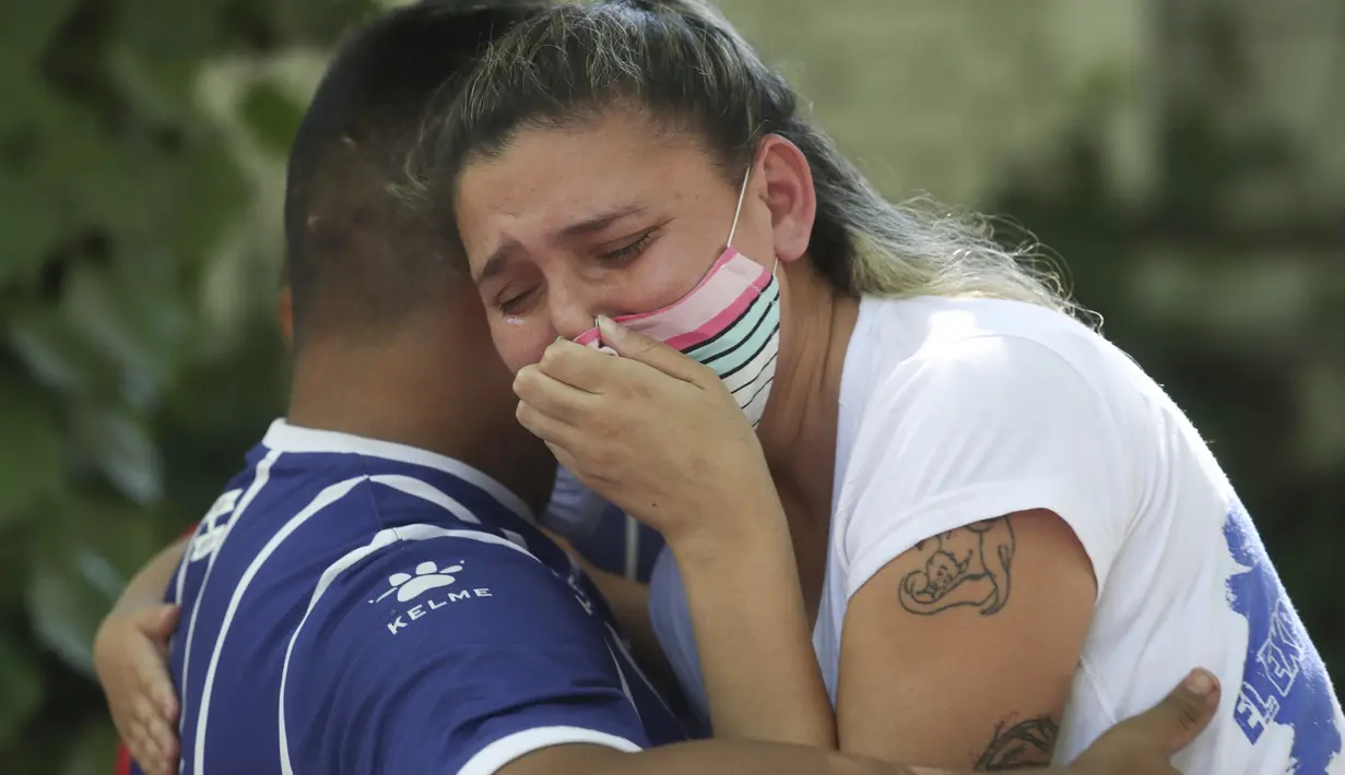 Seorang penggemar berduka di pintu masuk gedung apartemen tempat tinggal penyerang klub Argentina Godoy Cruz, Santiago ‘Morro’ Garcia, di Mendoza, Sabtu (6/2/2021). Pemain berusia 30 asal Uruguay tersebut ditemukan tewas diduga bunuh diri di apartemennya. (AP Photo/Marcelo Ruiz)