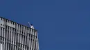 Pemanjat gedung pencakar langit asal Inggris George King bereaksi setelah memanjat Hotel Melia Barcelona Sky, Barcelona, Spanyol, 2 April 2021. George King mengatakan, saat bertemu polisi dalam perjalanan turun pikirannya masih berada di awang-awang. (Pau BARRENA/AFP)