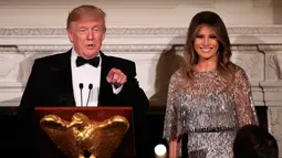 Presiden AS, Donald Trump dan Melania Trump memberikan sambutan pada jamuan makan malam White House Historical Association, Jumat (15/9). First Lady Amerika Serikat itu memadukan gaunnya dengan ikat pinggang dan perhiasan minimalis. (NICHOLAS KAMM / AFP)