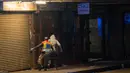 Afrika Selatan Lockdown 21 Hari: Polisi mengejar seorang pria saat berpatroli di pusat kota Johannesburg, Afrika Selatan, Jumat (27/3/2020). Polisi dan tentara mulai berpatroli beberapa saat setelah Afrika Selatan melakukan Lockdown 21 Hari  untuk mengurangi penyebaran Covid-19. (AP//Jerome Delay)