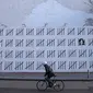 Seorang pengendara sepeda melewati tembok besar yang dimural oleh seniman Banksy di wilayah Manhattan, New York (15/3). Secara keseluruhan mural ini menggambarkan sosok Zehra Dogan yang berada di balik jeruji besi. (AFP Photo/Timothy A. Kliit)