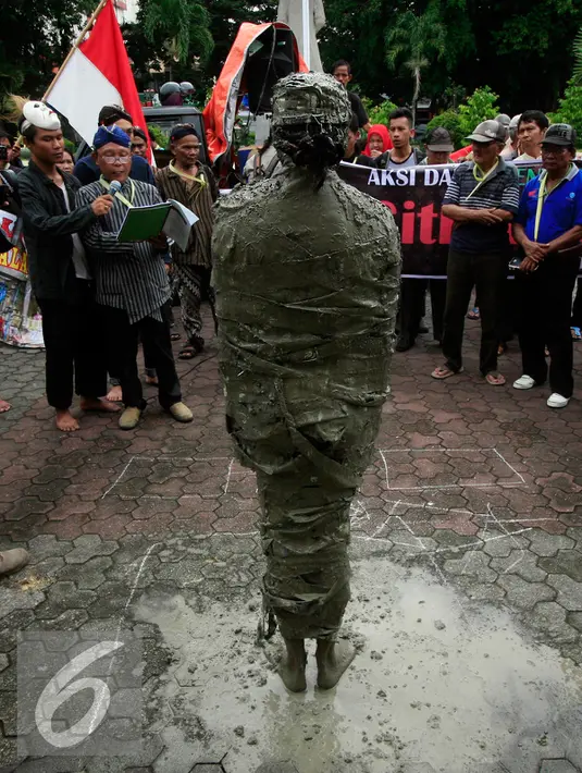 Seorang pengunjukrasa dari Aliansi Masyarakat Peduli Tata Ruang Yogyakarta megelar aksi teatrikal  manusia semen di Gedung DPRD DIY, (29/2). Mereka menuntut keseimbangan dalam fungsi dan kepemilikan ruang dengan masyarakat. (Liputan6.com/Boy Harjanto)