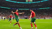 Pemain Portugal Cristiano Ronaldo merayakan gol pembuka timnya dengan Bruno Fernandes saat melawan Uruguay pada pertandingan sepak bola Grup H Piala Dunia 2022 di Stadion Lusail, Lusail, Qatar, 28 November 2022. Portugal mengamankan tempat di babak 16 besar usai membungkam Uruguay 2-0. (AP Photo/Themba Hadebe)