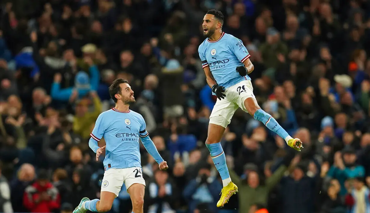 Pemain Manchester City Riyad Mahrez (kanan) melompat ke udara untuk merayakan gol ke gawang Chelsea pada pertandingan sepak bola Piala FA di Etihad Stadium, Manchester, Inggris, 8 Januari 2023. Manchester City mengalahkan Chelsea dengan skor 4-0. (AP Photo/Dave Thompson)