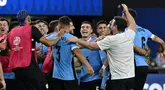 Gelandang Uruguay, Manuel Ugarte (tengah) merayakan dengan rekan setimnya setelah mencetak gol dalam adu penalti untuk memenangkan pertandingan perempat final Copa America 2024 melawan Brasil di Stadion Allegiant, Las Vegas, Nevada pada 6 Juli 2024 atau Minggu 7 Juli 2024 WIB. (Robyn BECK/AFP)