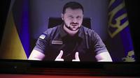 Presiden Ukraina Volodymyr Zelensky menyampaikan pidato lewat video yang disetel saat upacara pembukaan Festival Film Cannes edisi ke-75 di Cannes, Prancis selatan, Selasa (17/5/2022). Video Zelensky yang ditampilkan dalam acara pembukaan pun membuat kaget para tamu undangan. (Photo by Vianney Le Caer/Invision/AP)