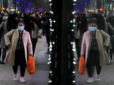 Pembeli terpantul di jendela saat mereka berjalan di Oxford Street, jalan perbelanjaan tersibuk di Eropa, di London, Kamis (23/12/2021). Meskipun pandemi covid-19, salah satu pusat perbelanjaan di London tersebut begitu ramai menjelang Natal. (AP Photo/Frank Augstein)