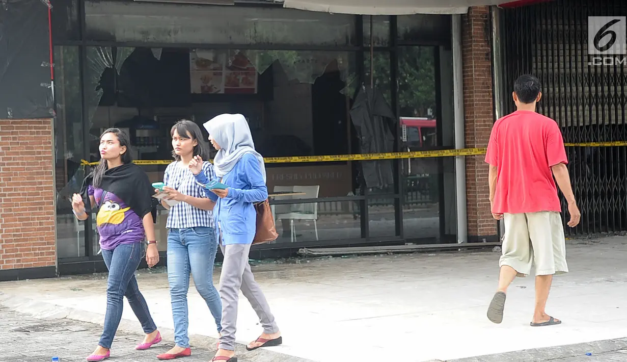 Sejumlah orang melintas di depan gedung pusat perbelajaan Ramayana, Pasar Minggu, Jakarta, yang terbakar, Kamis (18/5). Tidak ada korban jiwa dalam insiden yang diduga karena korsleting ini. (Liputan6.com/Yoppy Renato)