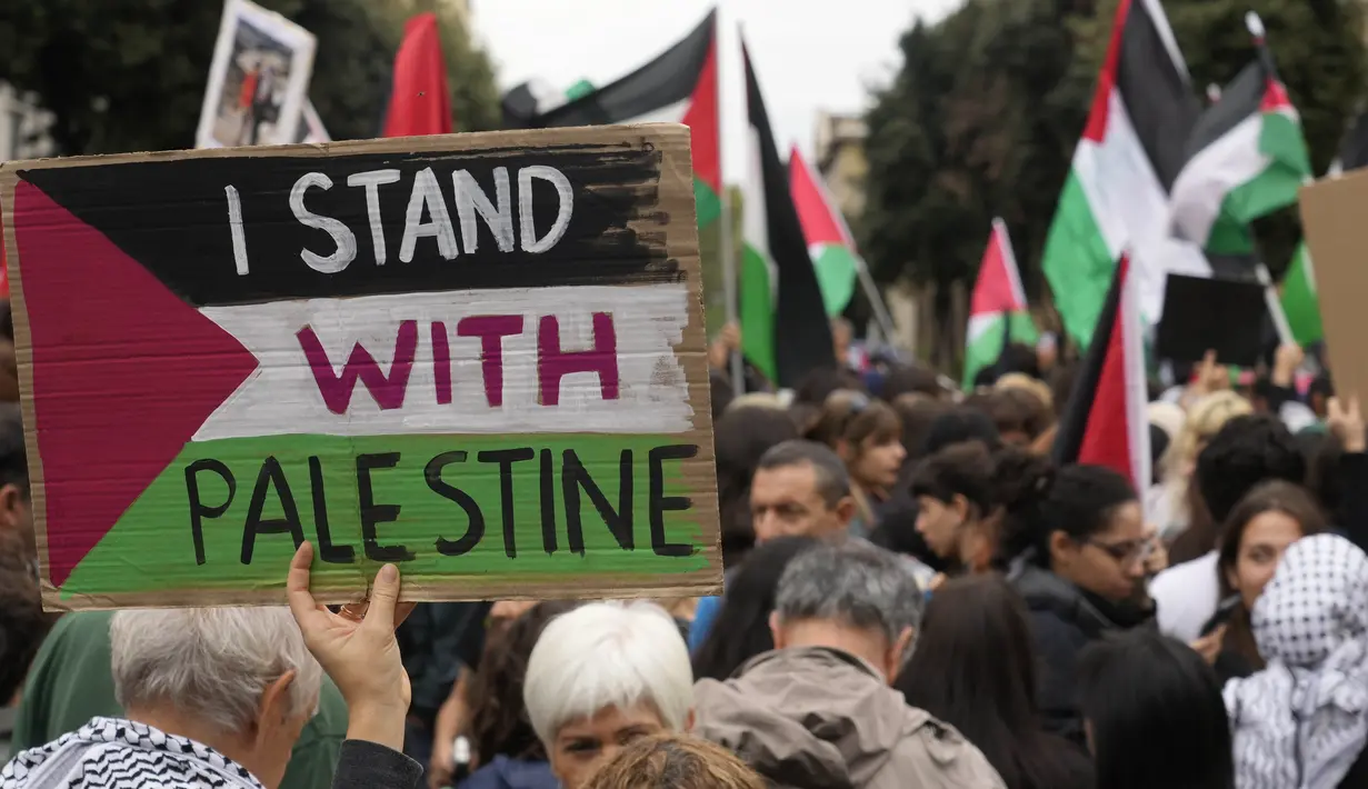 Para pengunjuk rasa memegang spanduk dan bendera saat mereka berkumpul untuk unjuk rasa pro-Palestina di Roma, Italia, Sabtu, 21 Oktober 2023. (AP Photo/Gregorio Borgia)