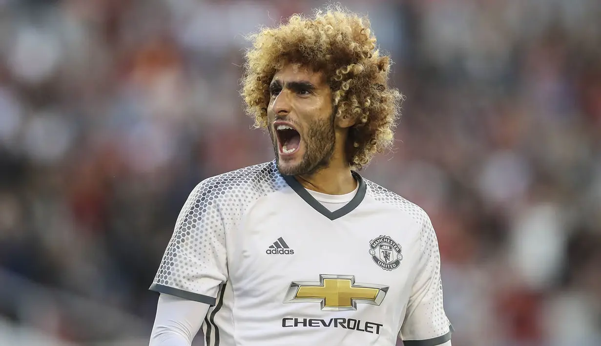 Gelandang Manchester United, Marouane Fellaini, merayakan gol yang dicetaknya ke gawang Galatasaray. Gol dari gelandang Belgia ini menutup pesta gol United menjadi 5-2. (AFP/TT News Agency) 