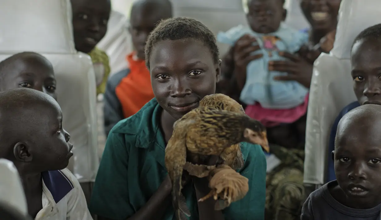 Sejumlah anak Sudan Selatan berada di dalam bus yang akan membawa mereka ke pusat transit pengungsi di Kuluba, Uganda utara, Kamis (8/6). (AP Photo / Ben Curtis)
