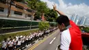 Atlet renang, peraih medali emas pertama Singapura, Joseph Schooling menyapa siswa sekolah saat keliling  menggunakan bus terbuka pada parade kemenangan di Singapura (18/08). (REUTERS/Edgar Su)