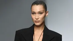 Model Bella Hadid mengenakan membawakan koleksi Spring 2020 dari Mugler dalam gelaran Paris Fashion Week, Rabu (25/9/2019). Bella Hadid menonjolkan bentuk alis serta matanya yang dirias ala smokey eye, dengan sapuan warna emas pada bibirnya. (Christophe ARCHAMBAULT / AFP)