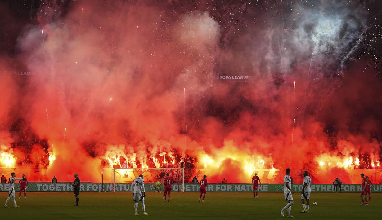 Pendukung FC Twente menyalakan suar dan kembang api menjelang dimulainya babak kedua pertandingan Liga Europa 2024/2025 melawan Besiktas di De Grolsch Veste stadium, Enschede, Belanda, Jumat (31/01/2025) dini hari WIB. (AP Photo/Peter Dejong)