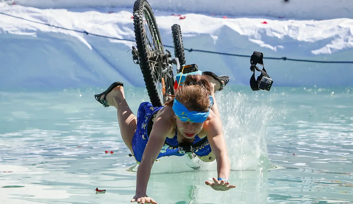 Peserta terjatuh akibat pendaratan yang tak sempurna saat meluncur di lintasan salju mengunakan sepeda dalam kontes Jump Red Bull dan Freeze di ski resort Chimbulak, Kazakhstan (22/3). (REUTERS/Shamil Zhumatov)