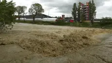 Aliran deras dari sungai Santerno yang letaknya bersebelahan dengan sirkuit Autodromo Enzo e Dino Ferrari, Rabu (17/5/2023). Sirkuit ini pun terkena banjir akibat luapan sungai yang letaknya tepat di sebelah sirkuit, meluap. (AP Photo/Luca Bruno)