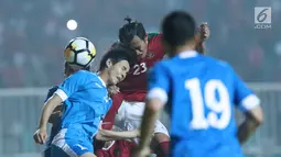 Kapten timnas Indonesia U-23, Hansamu Yama Pranata (tengah) berebut bola atas dengan pemain Uzbekistan, Alikulov Khusniddin pada laga PSSI Anniversary 2018 di Stadion Pakansari, Kab Bogor, Kamis (3/5). Laga imbang 0-0. (Liputan6.com/Helmi Fithriansyah)