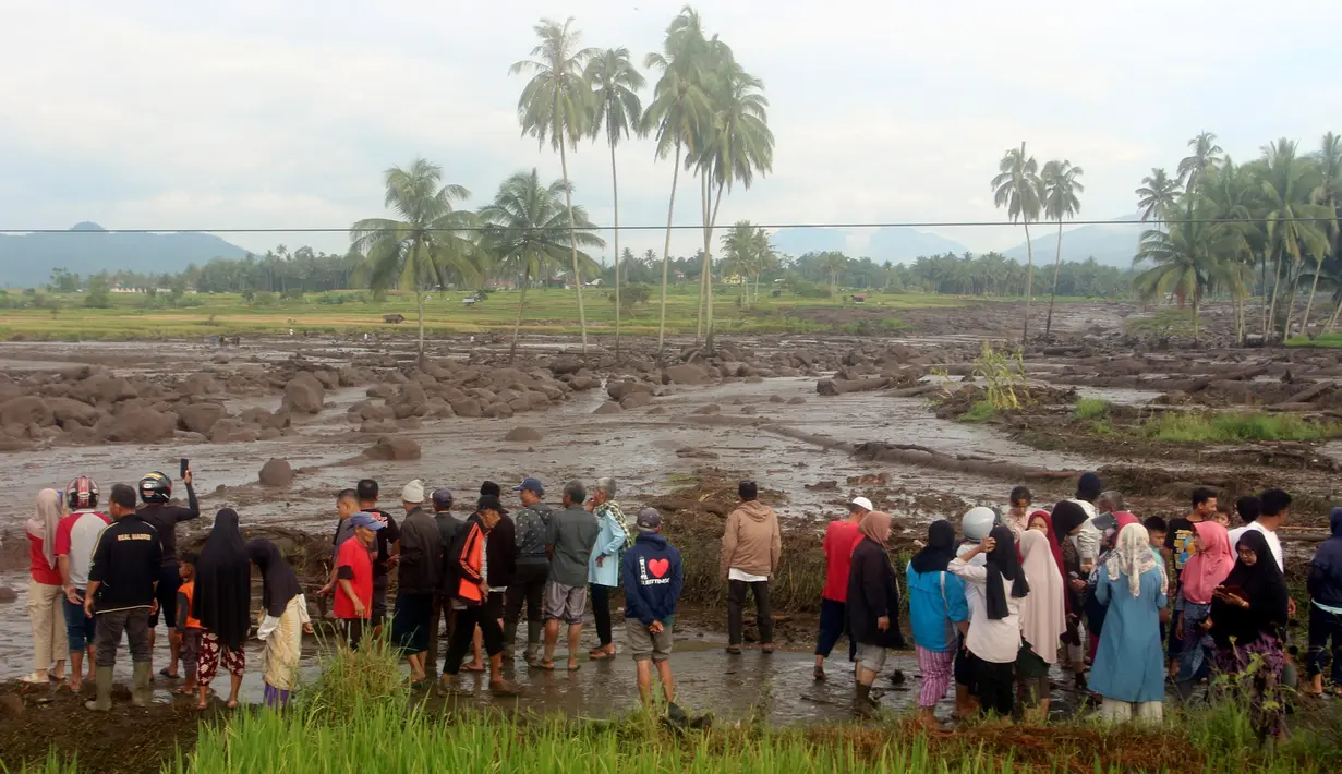 Orang-orang memeriksa daerah yang terkena dampak banjir bandang yang menewaskan sejumlah orang di Agam, Sumatra Barat, Indonesia, Minggu, 12 Mei 2024. (AP Photo/Ali Nayaka)