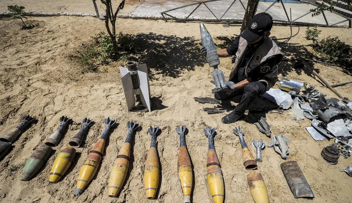 Seorang ahli bahan peledak Hamas menunjukkan proyektil yang tidak meledak setelah konflik Mei 2021 dengan Israel di kantor polisi setempat di Khan Yunis, Jalur Gaza, Sabtu (5/6/2021). Perang 11 hari antara Hamas dan Israel menewaskan 254 orang Palestina dan 12 orang Israel. (MAHMUD HAMS/AFP)