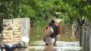 Warga melintasi banjir di Desa Karangligar dan Dusun Pengasinan kecamatan Teluk Jambe Barat, Kabupaten Karawang, Selasa (6/12/2022).  Banjir yang terjadi setelah hujan deras yang mengguyur sejak Minggu (4/12/2022) mulai berangsur surut. (merdeka.com/Imam Buhori)