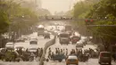 Orang-orang berjalan melintasi persimpangan saat badai pasir di Beijing, China, Kamis (6/5/2021). Debu dan badai pasir akhir musim semi mengirim indeks kualitas udara melonjak di Ibu Kota China pada hari ini. (AP Photo/Mark Schiefelbein)