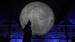 Seorang pria melewati pertunjukan cahaya malam di Lyon, Prancis tengah, Rabu (8/12/2021). Jutaan orang diperkirakan akan menghadiri acara Festival of Lights selama empat hari di kota itu. (AP Photo/Laurent Cipriani)