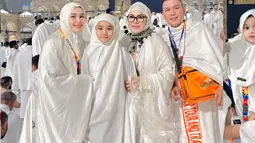 Potret Ayu dan keluarga di depan Ka'bah mencerminkan kebahagiaan dan kekhusyukan mereka. Mengenakan ihram putih, mereka tampak menikmati momen sakral di Masjidil Haram. Ka'bah yang megah di malam hari menambah kedamaian suasana.  (Liputan6.com/IG/@ayutingting92)