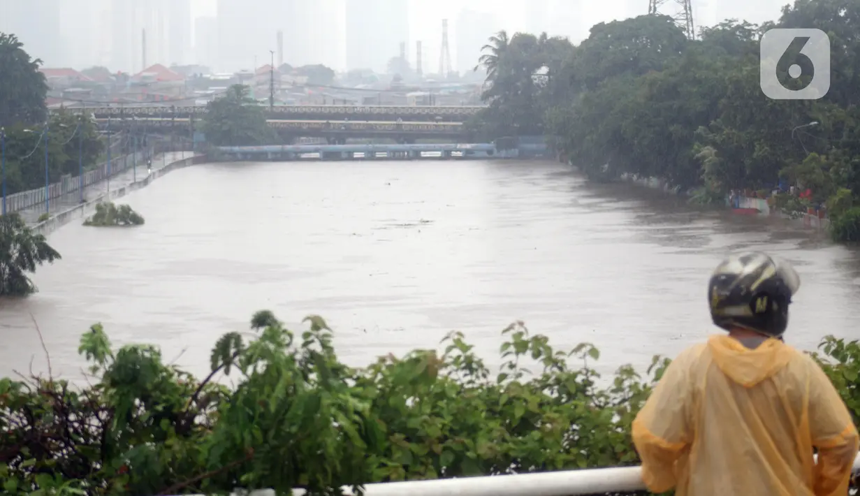 Warga melihat-lihat kondisi Banjir Kanal Barat di Kawasan Tanah Abang, Jakarta, Rabu (1/1/2020). Hujan yang mengguyur Jakarta sejak Selasa sore (31/12/2019) mengakibatkan debit air Banjir Kanal Barat tinggi dan hampir meluap. (Liputan6.com/Helmi Fithriansyah)