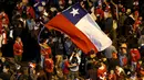 Suporter Chili mengibarkan bendera nasional Chili merayakan kemenangan Chili atas Argentina di final Copa Amerika 2015 di Santiago, (4/7/2015). Chili menang lewat adu penalti atas Argentina dengan skor 4-1. (REUTERS/Andres Stapff)