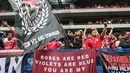 Suporter tim Garuda melambaikan spanduk dan bersorak sebelum dimulainya pertandingan putaran ketiga kualifikasi Piala Dunia 2026 grup C antara Jepang dan Indonesia di Osaka pada 10 Juni 2025. (PAUL MILLER/AFP)
