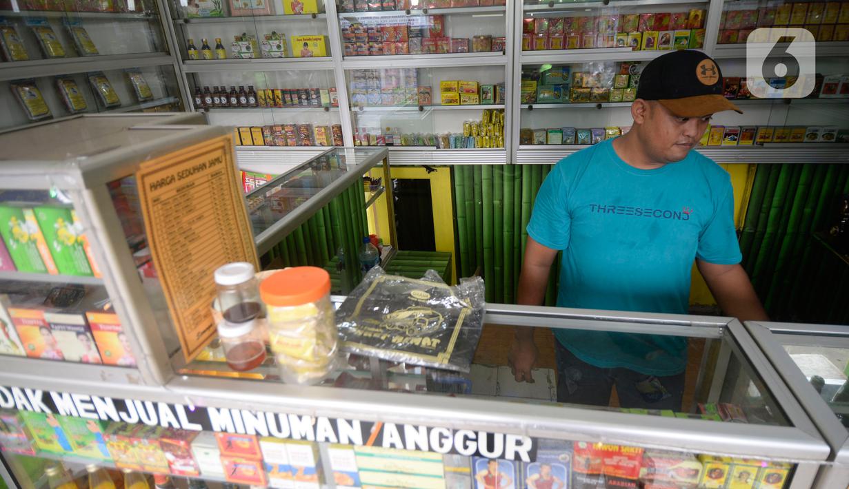 Hendri (37) penjual jamu aduk menunggu pembeli di kawasan Pamulang, Tangerang Selatan, Banten, Senin (289/2020). Menurutnya penjualan jamu aduk pada masa musim pandemi Covid 19 satu bulan ini penjualan meningkat hingga 200 persen dibandingkan bulan sebelumnya. (merdeka.com/Dwi Narwoko)