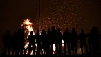 Sejumlah orang mengikuti tradisi malam San Juan's (Saint John) di Gijon, Spanyol, (24/6). Malam San Juan adalah upacara penyucian dimana warga membakar sejumlah benda yang sudah tidak diinginkan. (REUTERS/Eloy Alonso)