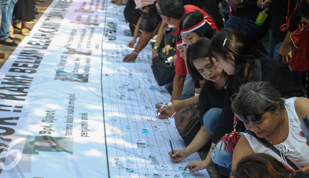 Para pendukung Ahok membubuhkan tandatangan saat aksi di depan Balaikota, Jakarta, Sabtu (13/5). Massa pendukung Ahok menggelar aksi pengumpulan KTP untuk membebaskan Ahok dari jeratan vonis dua tahun penjara. (Liputan6.com/Yoppy Renato)