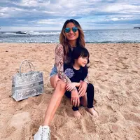 Main di pantai, penampilan chic Acha saat momong anak dengan printed long sleeve dan short pants cur