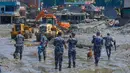 Polisi Nepal mengawasi saat alat berat menyingkirkan puing-puing akibat banjir bandang di distrik Nuwakot, Nepal, Kamis, 27 Agustus 2026. (Foto AP/Niranjan Shrestha)