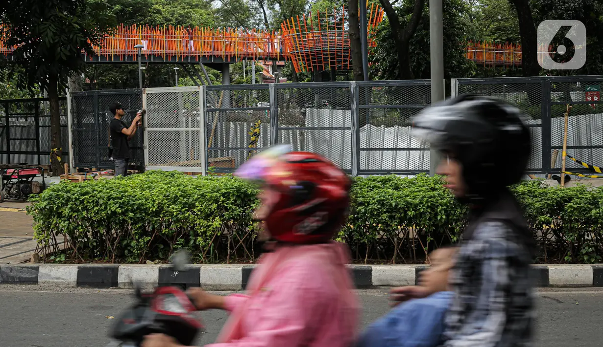 Pekerja melakukan pengelasan saat menyelesaikan pemasangan pagar yang mengelilingi area ruang terbuka hijau (RTH) Tebet Eco Park, Jakarta, Senin (12/12/2022). Pemprov DKI Jakarta melakukan pembatasan jumlah pengunjung taman dengan pembuatan sistem pendaftaran masuk pengunjung melalui JAKI sejak Juli 2022. (Liputan6.com/Faizal Fanani)