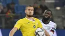 Pemain Rumania George Puscas (kiri) berebut bola dengan pemain Jerman Antonio Ruediger pada pertandingan Grup J kualifikasi Piala Dunia Qatar 2022 di Hamburg, Jerman, 8 Oktober 2021. Jerman menang 2-1. (John MACDOUGALL/AFP)