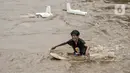 Seorang anak berenang di Kali Ciliwung yang meluap, Kebon Pala, Jatinegara, Jakarta Timur, Minggu (31/10/2021). Aliran Kali Ciliwung yang meluap akibat hujan di kawasan hulu dimanfaatkan anak-anak untuk berenang meski membahayakan keselamatan. (merdeka.com/Iqbal S. Nugroho)